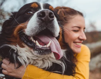 Uma moça abraçando seu cachorro após garantir o plano preventivo de assistência funerária pet